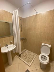 een badkamer met een douche, een toilet en een wastafel bij Saranda relax apartments in Sarandë