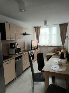 a kitchen and living room with a table and a dining room at Apartament u Ani in Wrocław