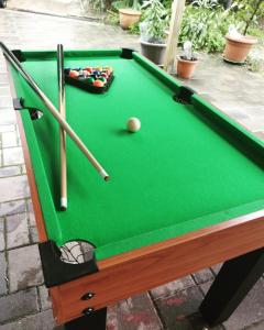 a green pool table with a ball and bats at Rákóczi Guesthouse Miskolc in Miskolc