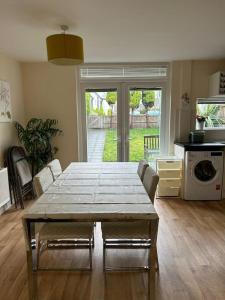 a living room with a table and a kitchen at Cosy House near city centre and football stadium in Manchester