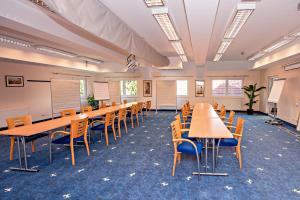 a classroom with tables and chairs in a room at Hotel Wiental in Pressbaum