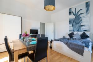 a bedroom with a bed and a dining room with a table at Yeshello Apartment Central Station in Vienna