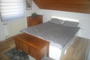 - une chambre avec un lit et une table en bois dans l'établissement Savinja River Residence, à Ljubno