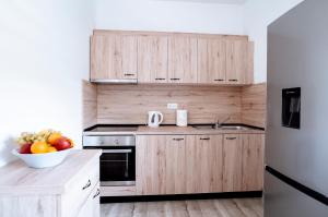 eine Küche mit Holzschränken und einer Schale Obst in der Unterkunft Apartman Ružić in Sveti Ivan Žabno