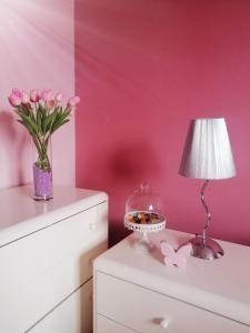 einen Tisch mit einer Lampe und einer Vase rosa Blumen in der Unterkunft Room near city center Butterfly in Split