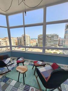 a room with chairs and tables and large windows at Cozy Apartment in central Almada w Swing Chairs in Almada