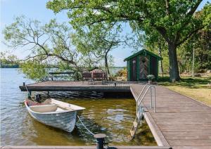 a small boat on the water next to a dock at Escape to Your Very Own Private Island - Just 30 Minutes from Stockholm in Svartsjö