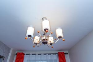 a chandelier hanging from a ceiling in a room at The Bliss - Lovely 1 bedroom apartment located near TRM mall in Nairobi