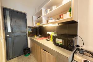cocina con encimera y microondas en The Bliss - Lovely 1 bedroom apartment located near TRM mall, en Nairobi