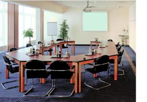 een conferentieruimte met een grote houten tafel en stoelen bij Panorama Hotel in Glashütten