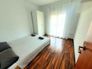 una camera con letto e pavimento in legno di Apartamento en el centro de Playa de Aro a Platja  d'Aro