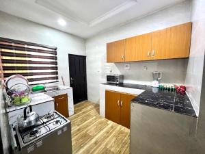una cucina con piano cottura e piano di lavoro di CampDavid Luxury Apartments Ajao Estate Airport Road Lagos 0 8 1 4 0 0 1 3 1 2 5 a Lagos