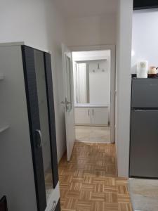 a room with a kitchen with a refrigerator and a hallway at Apartman IRIS in Bijeljina