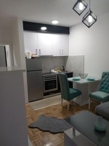 a kitchen and living room with a table and chairs at Apartman IRIS in Bijeljina