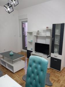 a living room with a blue chair and a table at Apartman IRIS in Bijeljina