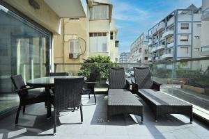 a patio with a table and chairs on a balcony at Mamma Mia by HolyGuest in Tel Aviv