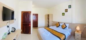 a bedroom with a bed and a flat screen tv at Downtown Vang Vieng Hotel in Vang Vieng