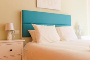 una camera con letto con testiera blu e tavolo di Centrally located 2 bed apartment los alcazares a Los Alcázares