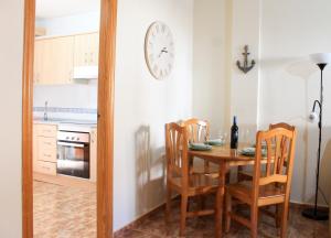 une cuisine avec une table, des chaises et une horloge murale dans l'établissement Centrally located 2 bed apartment los alcazares, à Los Alcázares