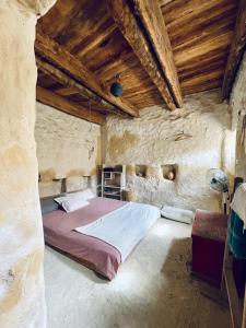 a bedroom with a bed in a stone building at Baben Home in Siwa