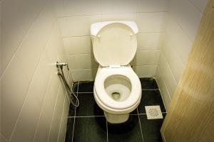 a small bathroom with a toilet in a stall at Upspot Kuching Waterfront Premium Hostel in Kuching