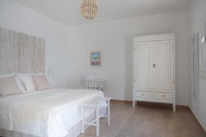 a white bedroom with a white bed and a cabinet at Lovin Puglia Vacation in Bari