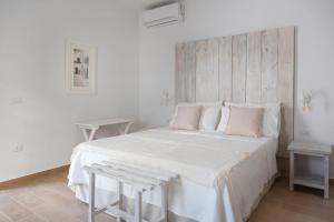 a white bedroom with a large white bed with pink pillows at Lovin Puglia Vacation in Bari