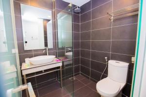 a bathroom with a toilet and a sink and a mirror at Urban Inn Kulim in Kulim