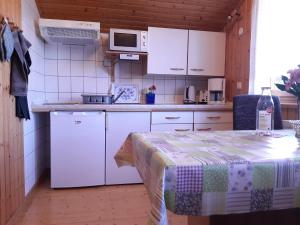 una cocina con electrodomésticos blancos y una mesa en una habitación en Landhof Kützin Ferienhaus Fink 5 