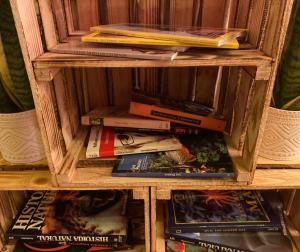uma pilha de livros numa estante de livros de madeira em SabiaNatura - boutiqueMadrid em Madri