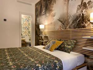 a bedroom with a bed with a floral bedspread at SabiaNatura - boutiqueMadrid in Madrid