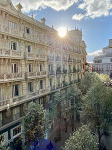 ein großes Gebäude, hinter dem die Sonne scheint in der Unterkunft SabiaNatura - boutiqueMadrid in Madrid