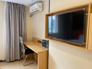 a room with a desk and a flat screen tv at 7Days Premium Guangzhou Chenjiaci Dukang Avenue in Guangzhou