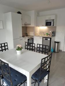 eine Küche mit einem weißen Tisch und Stühlen in der Unterkunft Superbes appartements neufs à Montpellier in Montpellier