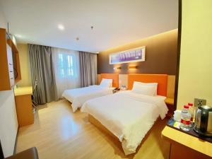 a hotel room with two beds in a room at 7Days Premium Guangzhou Chenjiaci Dukang Avenue in Guangzhou