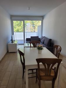 ein Wohnzimmer mit einem Tisch, Stühlen und einem Sofa in der Unterkunft Superbes appartements neufs à Montpellier in Montpellier