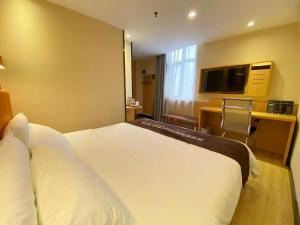a hotel room with a bed and a television at 7Days Premium Guangzhou Chenjiaci Dukang Avenue in Guangzhou
