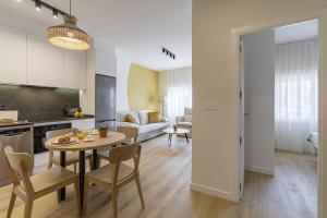 eine Küche und ein Wohnzimmer mit einem Tisch und Stühlen in der Unterkunft BALI Premium Apartments 1 bedroom in Benicàssim