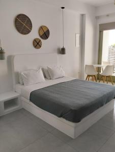 a white bedroom with a bed and a table at Allegro suite in Tinos Town