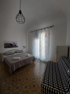 a white room with a bed and a window at Struttura Le Gemme in Marettimo