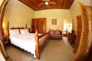 um quarto com uma cama e uma ventoinha de tecto em Charela Inn em Negril
