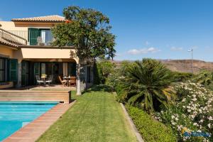 een huis met een zwembad en een tuin bij Villa Monte Leon in Maspalomas