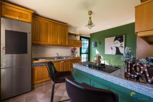 een keuken met houten kasten en een groene muur bij Villa Monte Leon in Maspalomas