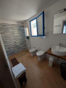 a bathroom with two toilets and two sinks and a window at Struttura Le Gemme in Marettimo
