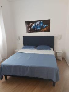 een slaapkamer met een groot bed en een blauwe deken bij Struttura Le Gemme in Marettimo