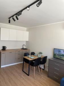 a kitchen with a table and chairs in a room at Seaside apartaments Self check in in Juodkrantė