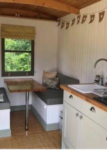 a small kitchen with a sink and a window at The Warren - Cosy Shepherds Hut in beautiful wild meadow in Halesworth