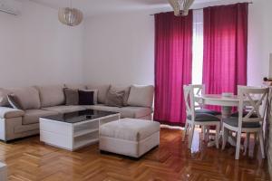 - un salon avec un canapé et une table dans l'établissement Lanai Apartment, à Trebinje