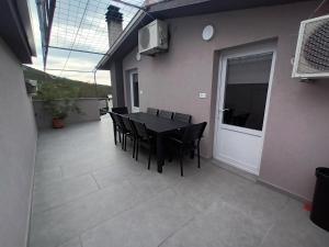 een zwarte eettafel en stoelen op een patio bij Apartman Štrkalj in Tisno