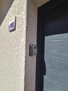una puerta con una señal en el lateral de un edificio en PAUSE NATURE Maison Cosmos avec parking gratuit, en Lapeyrouse-Fossat